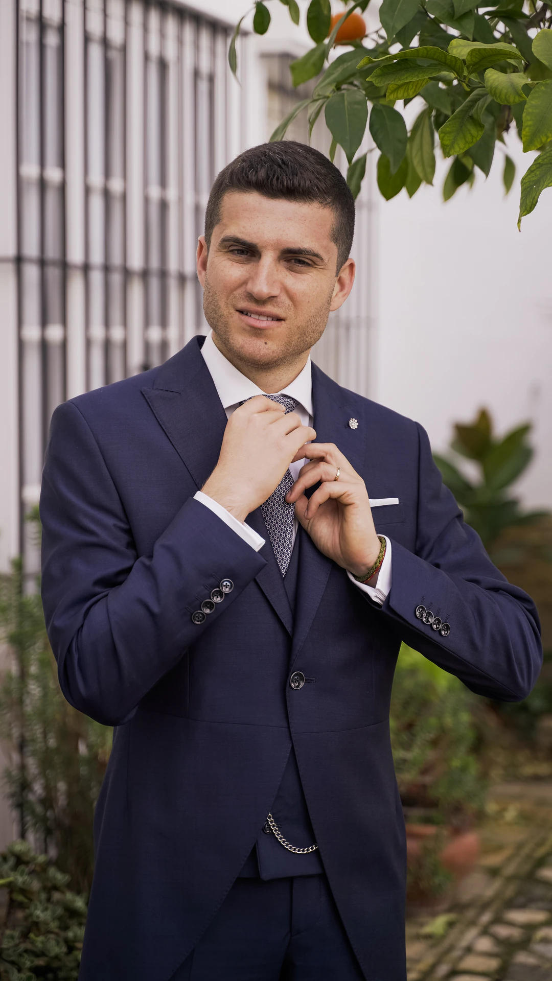 Álvaro se ajusta la corbata en un patio
