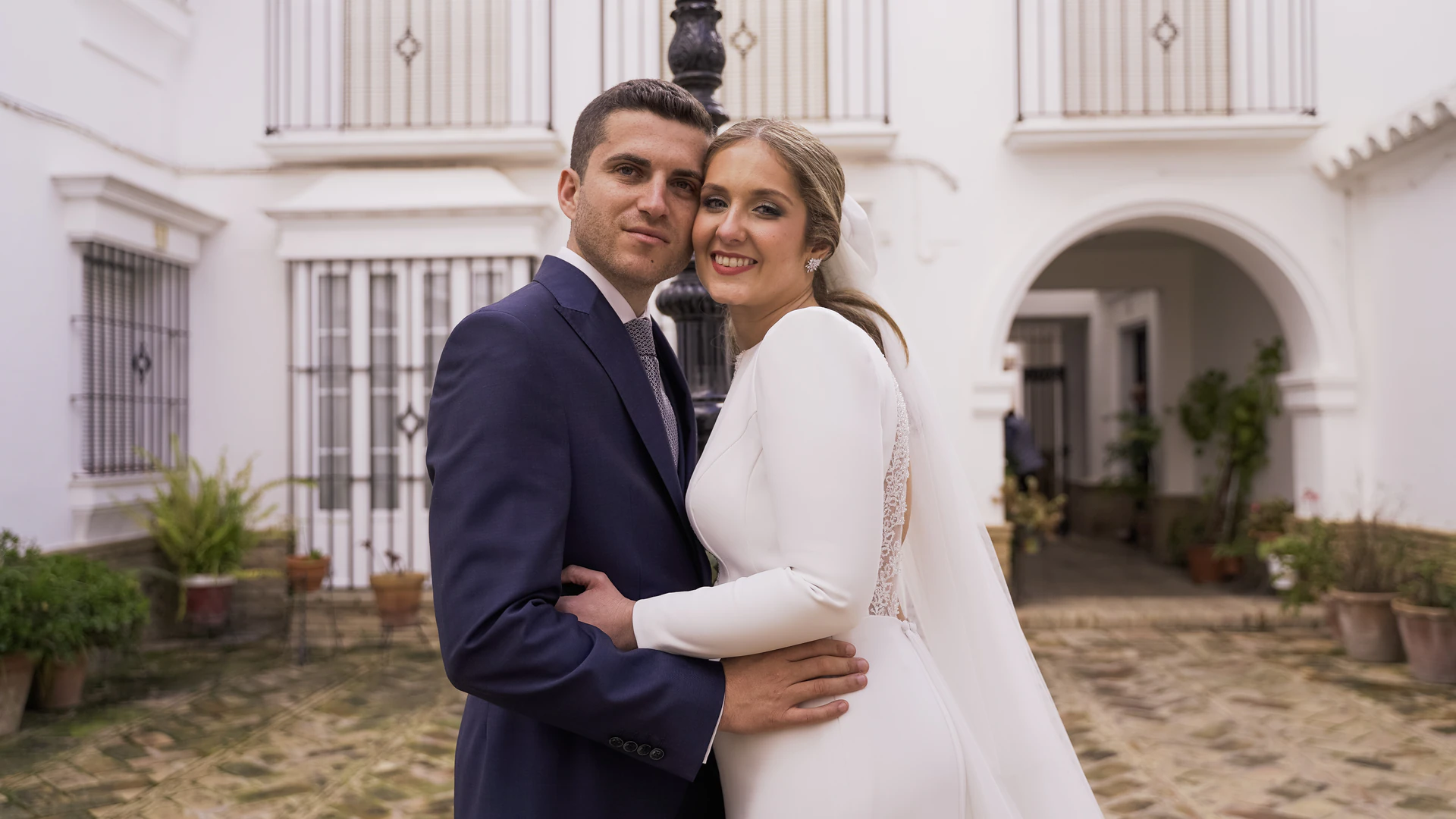 Álvaro y Patricia abrazados en un patio blanco