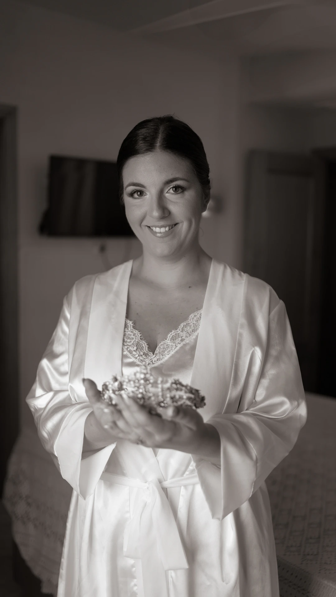Laura, con bata blanca, sostiene la tiara, en blanco y negro