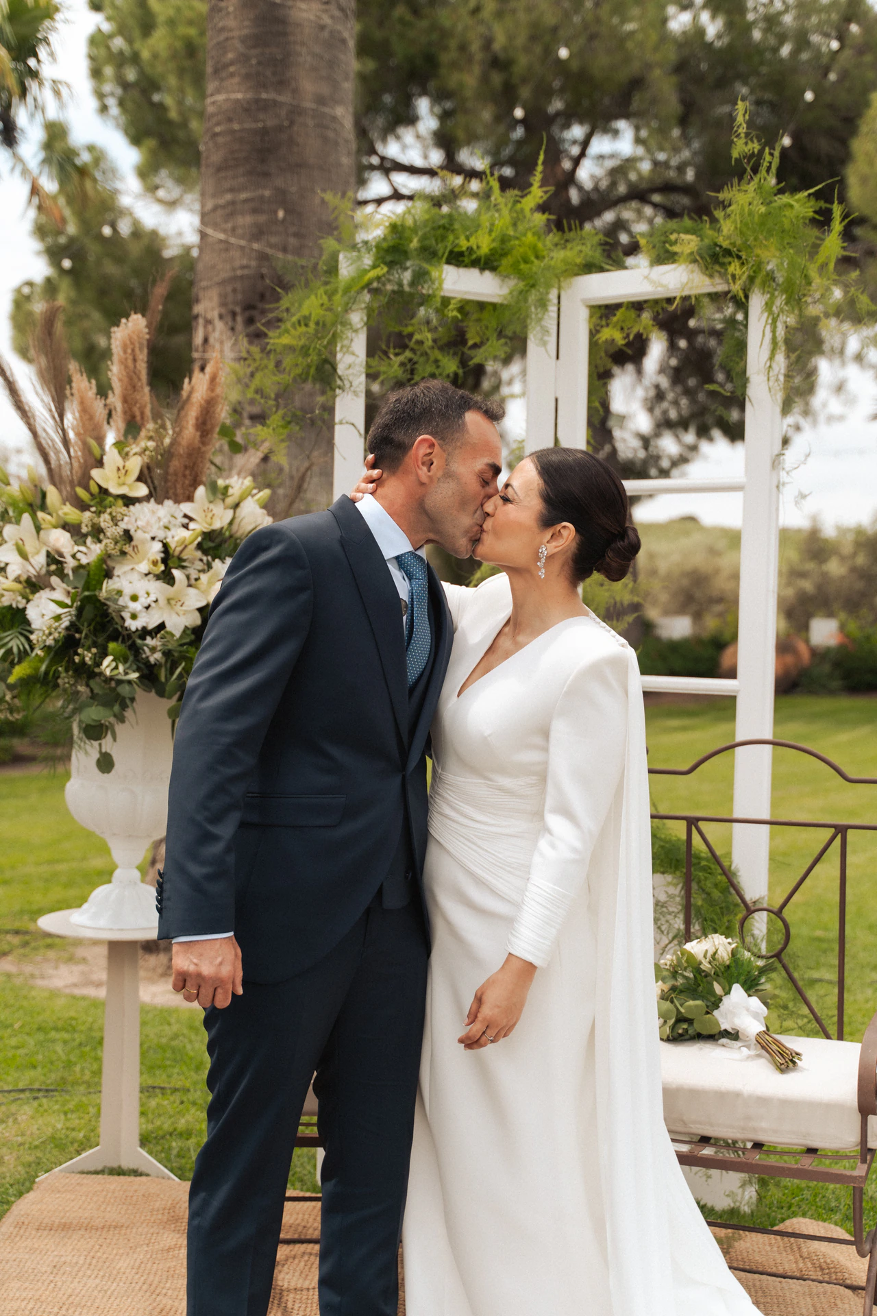 Lupe y Fernando se besan en la ceremonia al aire libre, bajo los árboles
