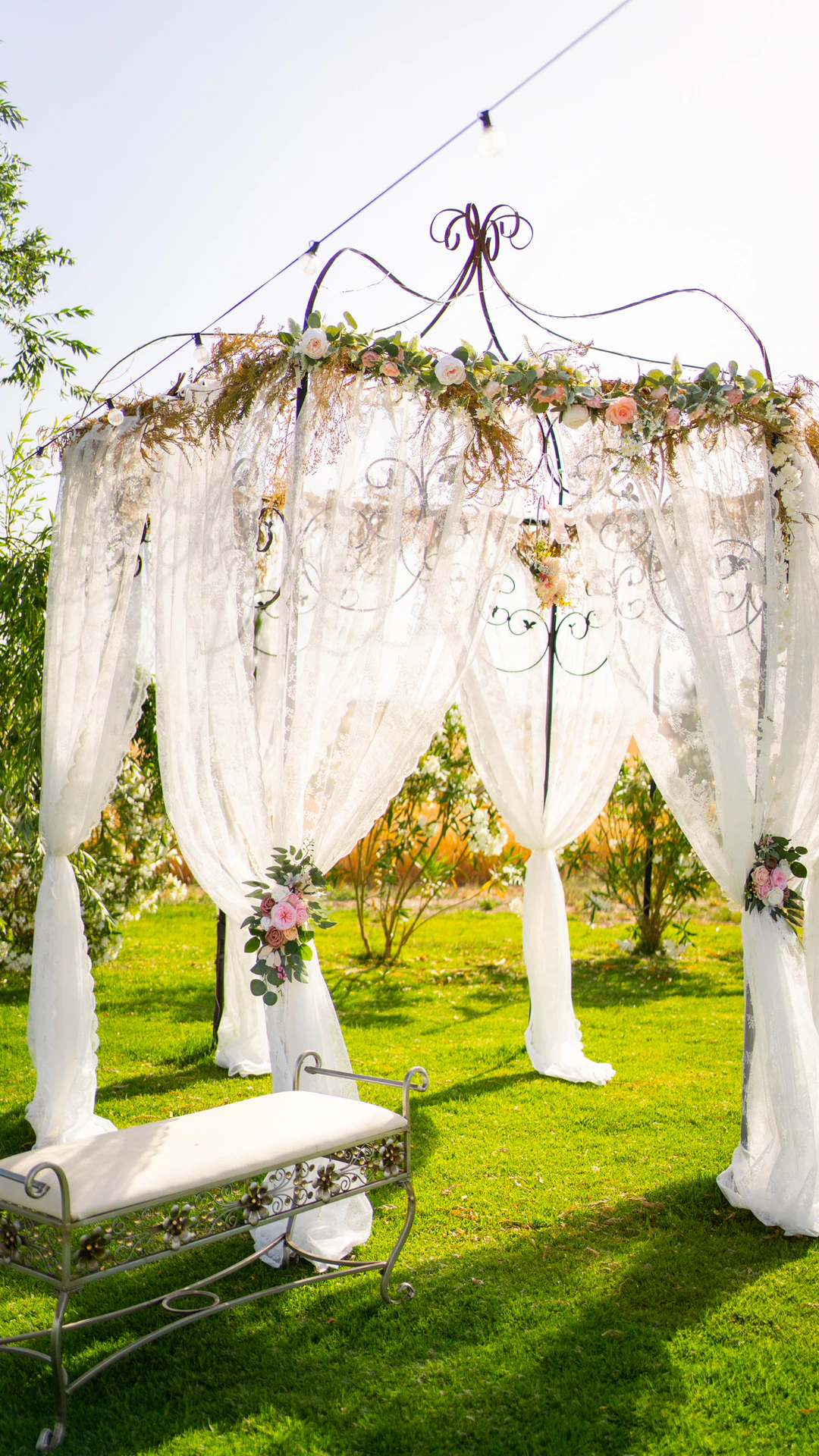 Altar con cortinas blancas y flores en el jardín