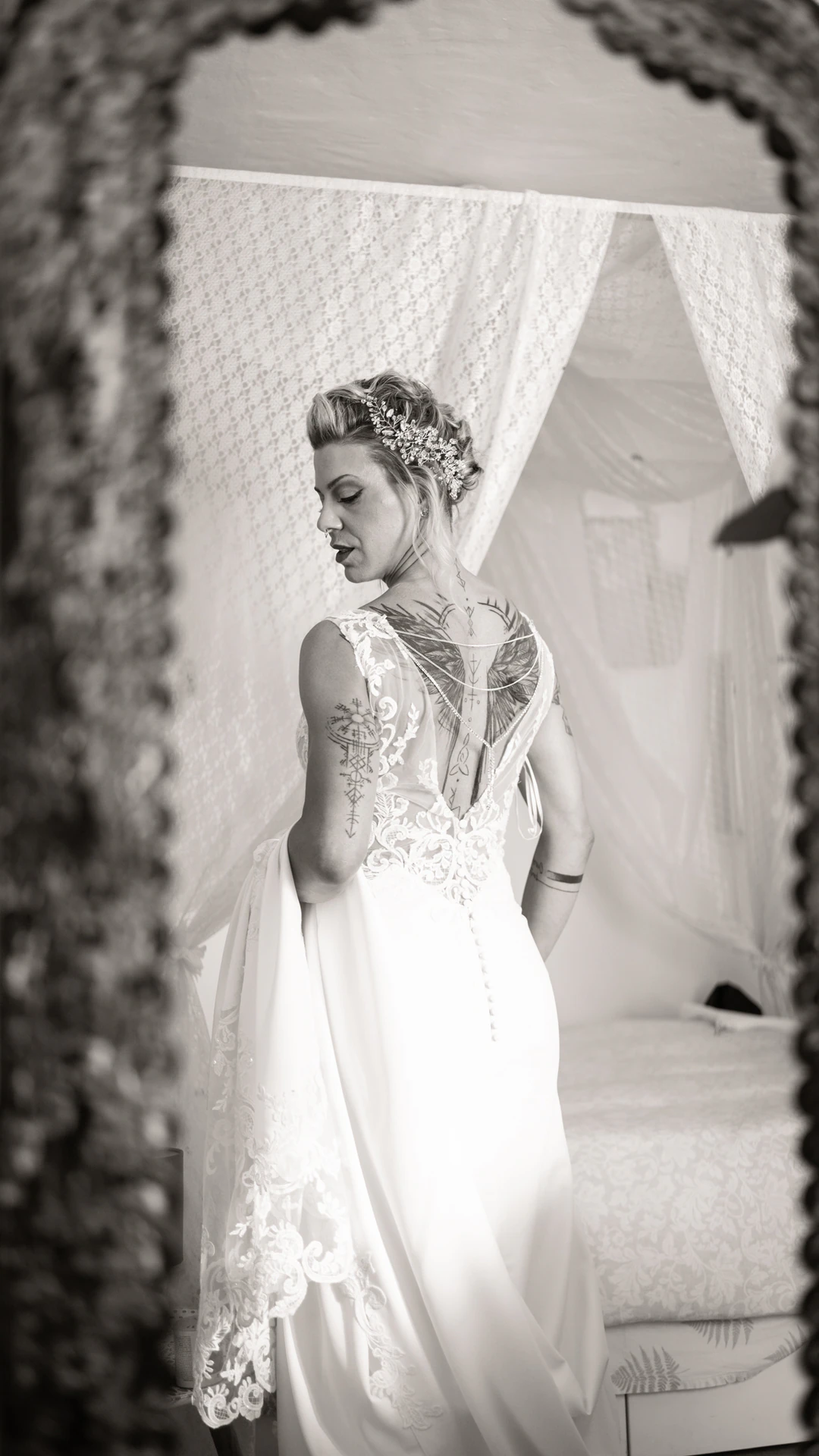 Una de las novias, de espaldas, reflejada en un espejo, en blanco y negro