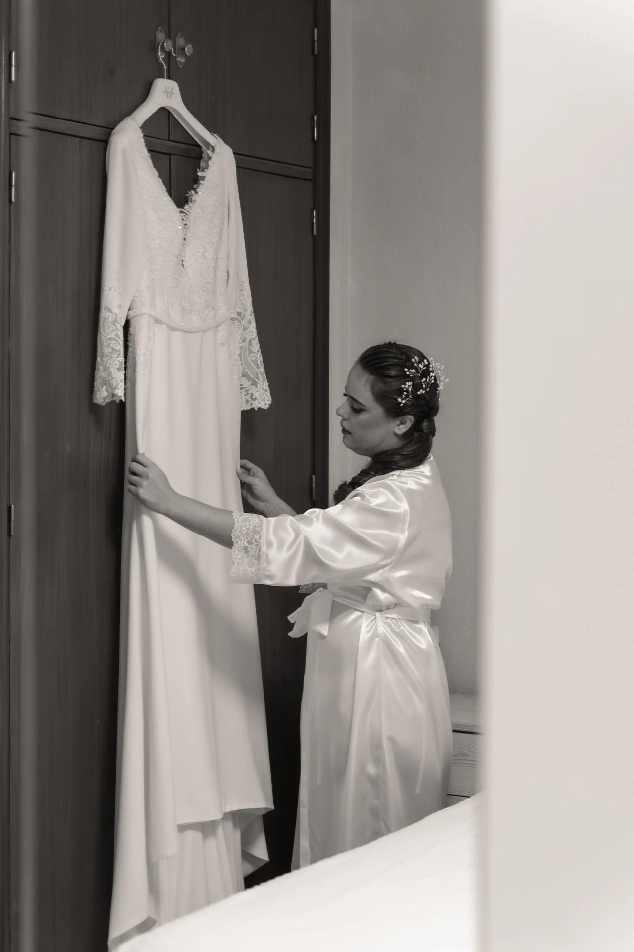 Una de las novias junto a su vestido colgado, en blanco y negro