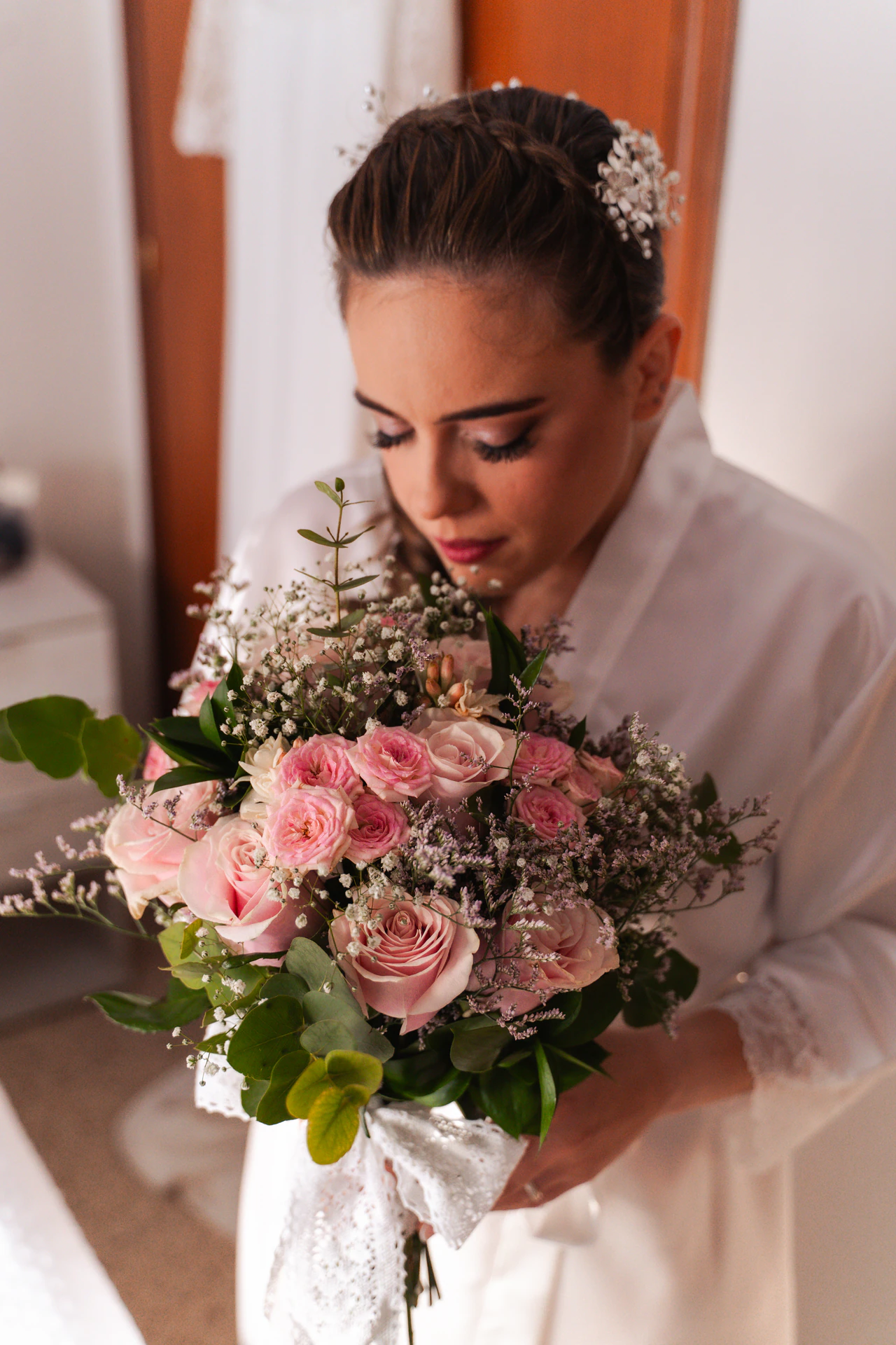 Una de las novias mira su ramo de rosas