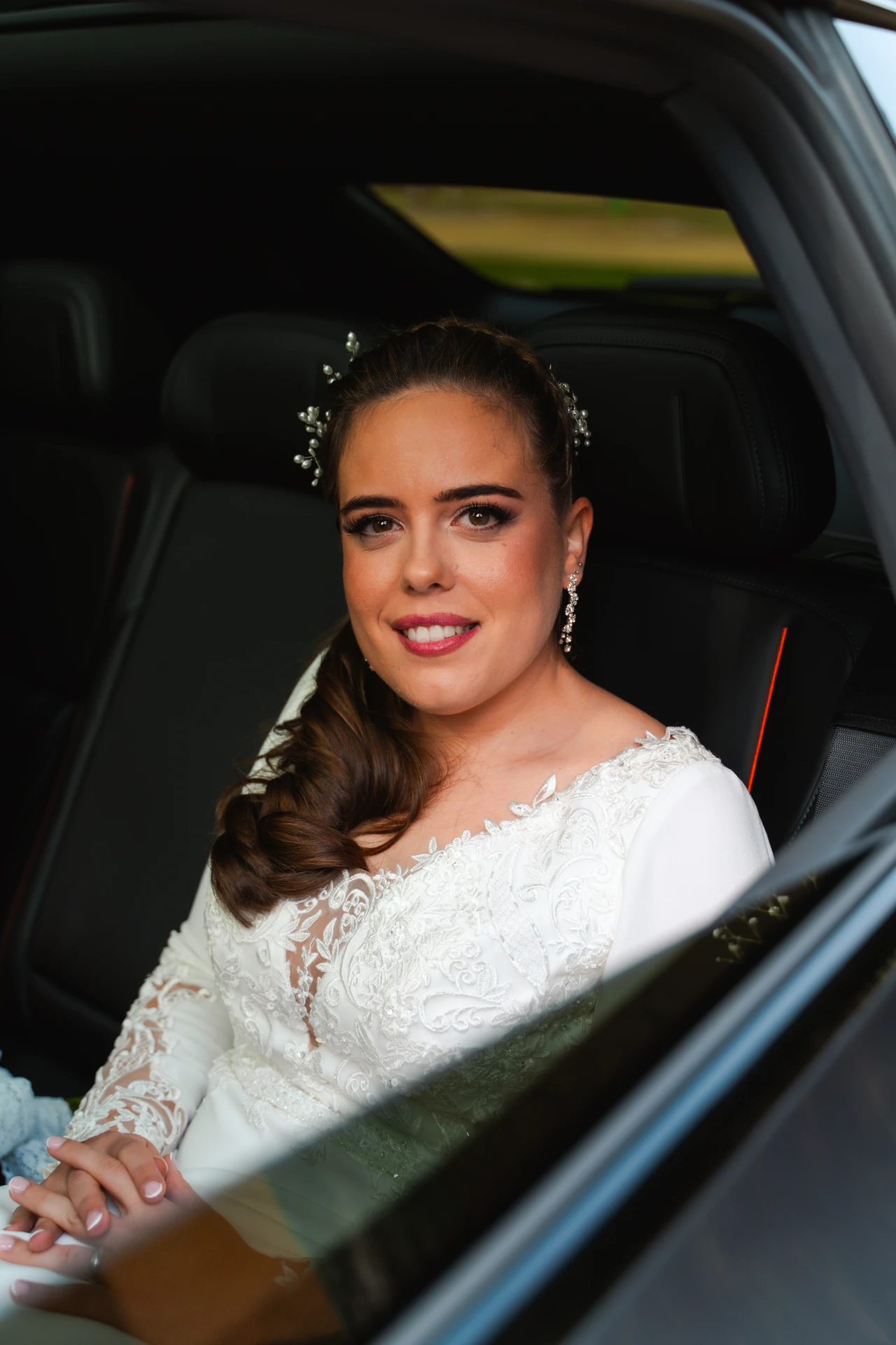 Una de las novias sonríe desde el coche